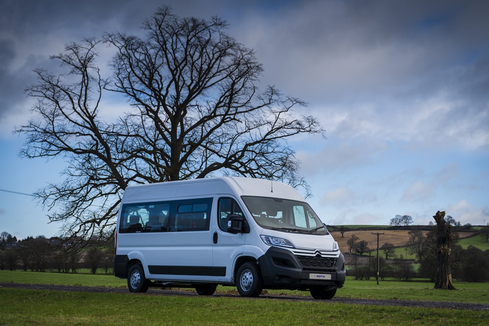 Glasgow Coach Hire: A spacious, modern coach traveling through the streets of Glasgow, providing comfortable and reliable transportation for group events.